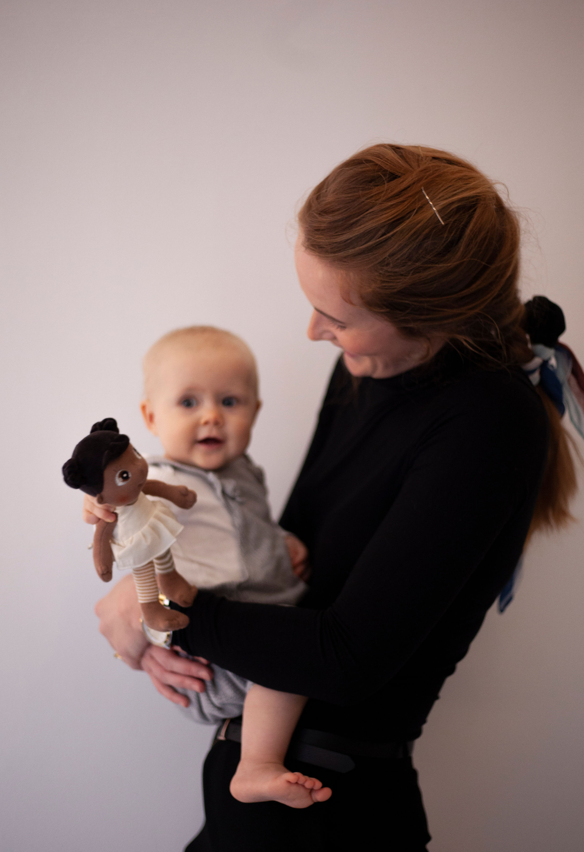 Frau zeigt einem Baby die Rubens EcoBuds Mini-Puppe Flora