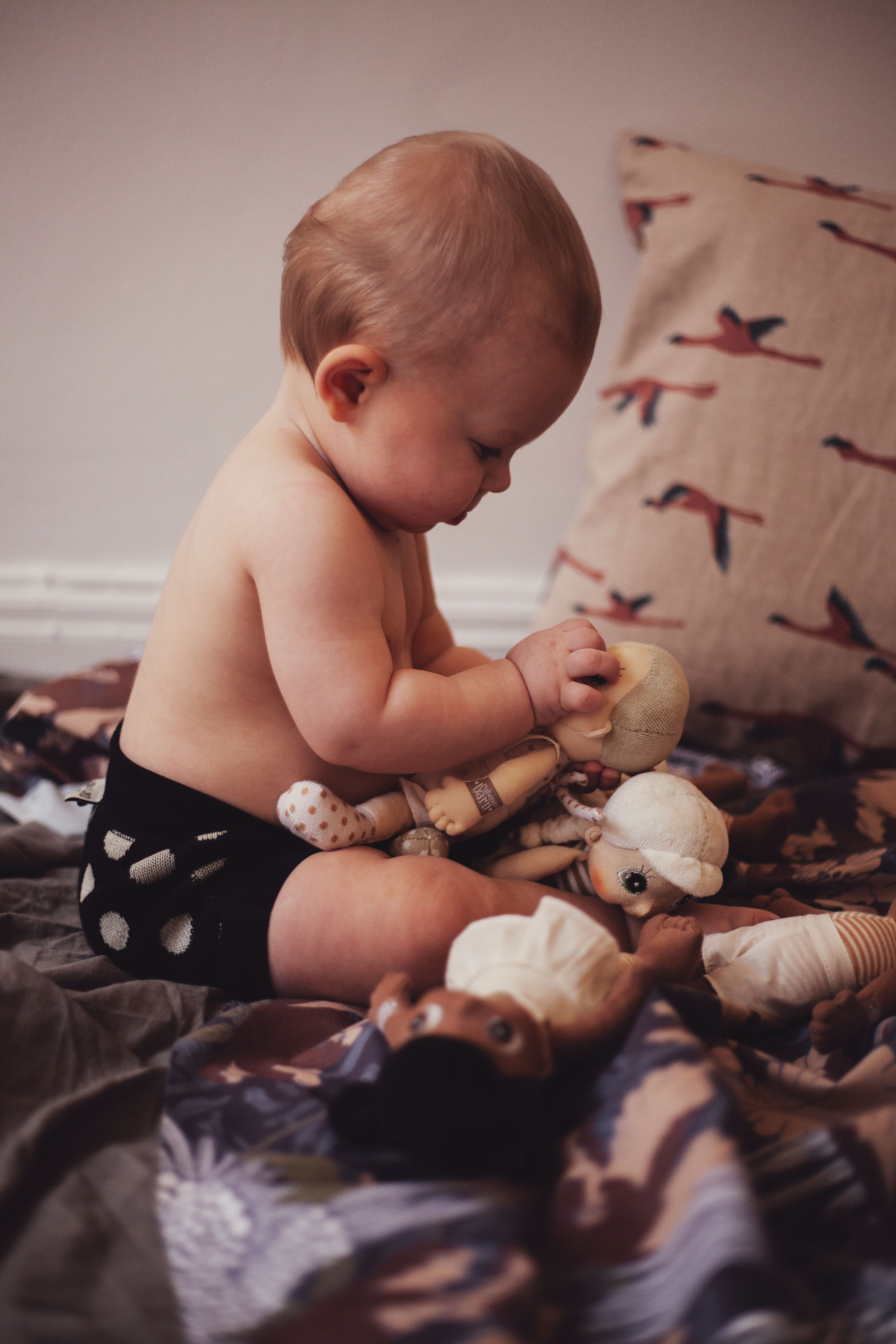 Baby betrachtet eine Rubens EcoBuds Mini-Puppe beim Spielen