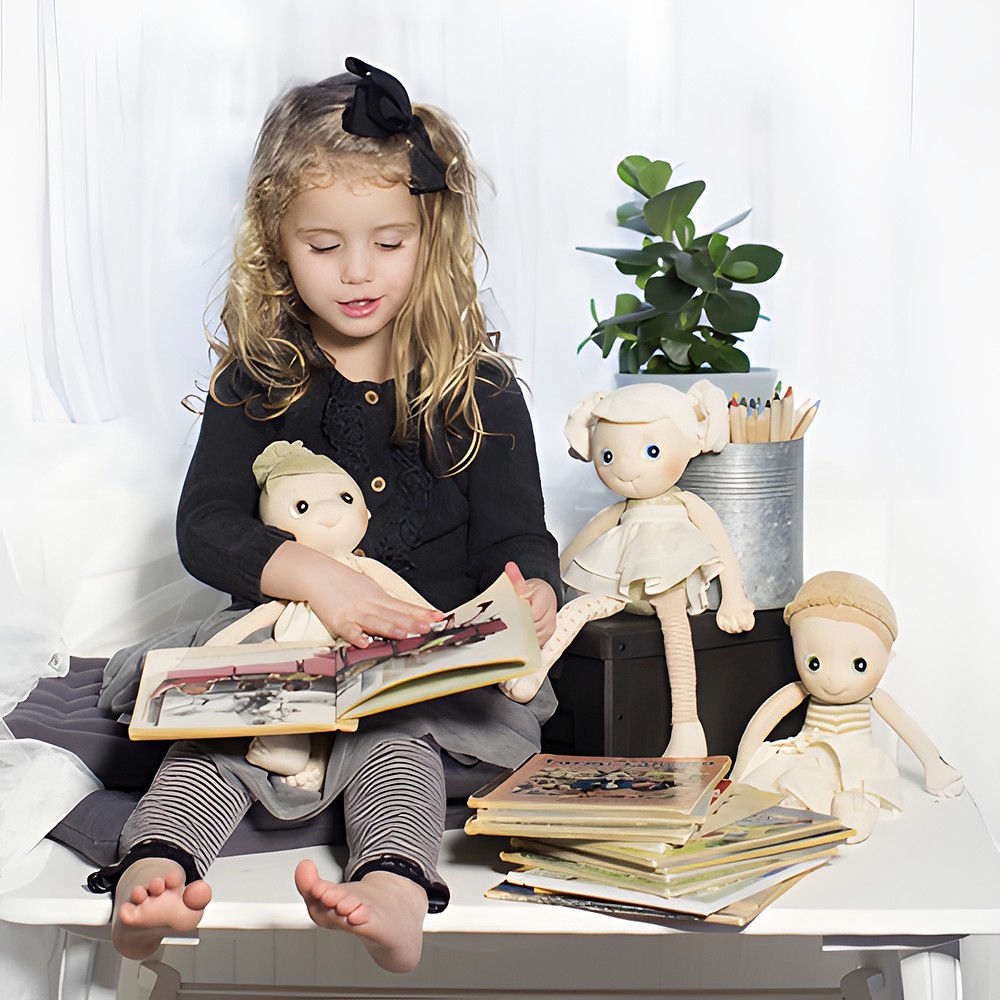 Child reading to the Rubens EcoBuds dolls, Daisy on their lap